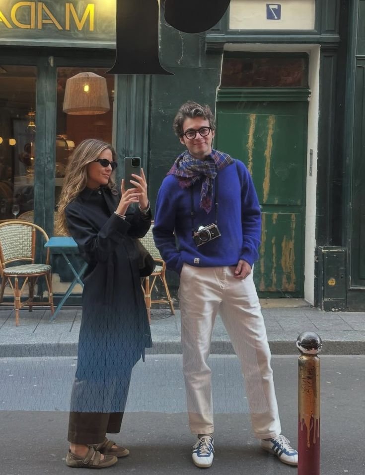 Deux personnes en vêtements minimalistes avec jeans et chemises sobres dans un cadre urbain chic.