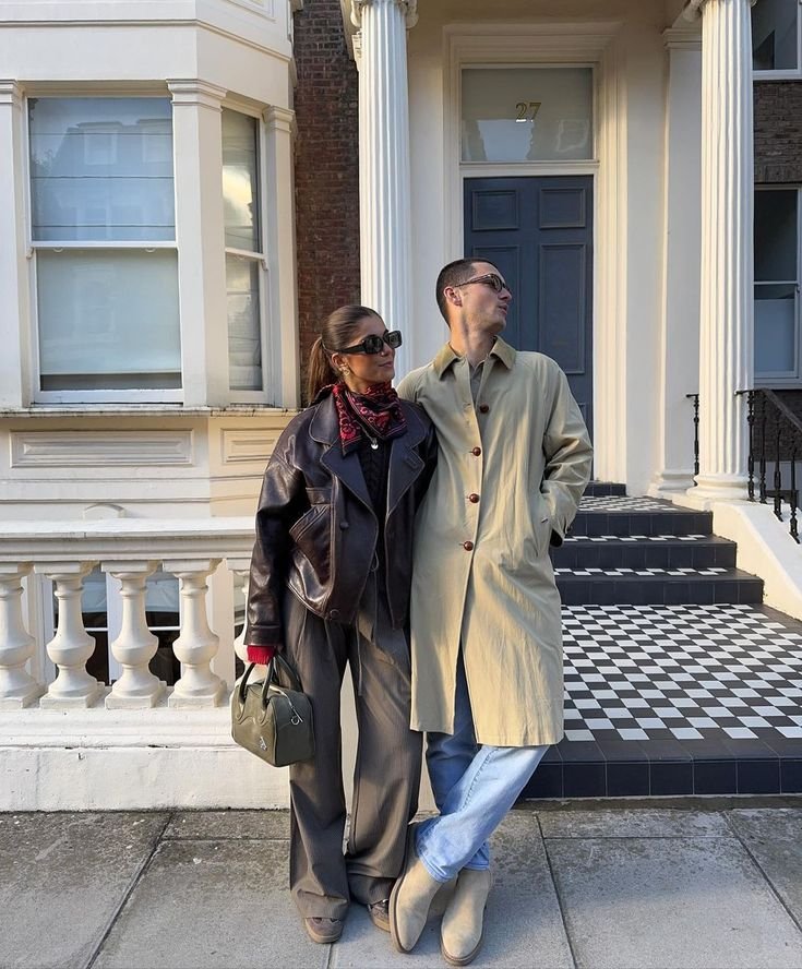 Couple en extérieur habillé de vêtements minimalistes avec manteaux sobres et accessoires discrets.