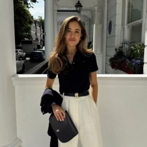 Femme portant le pantalon large Palazzo "Marbella" Riviera en lin écru, ajusté par une ceinture fine dorée.