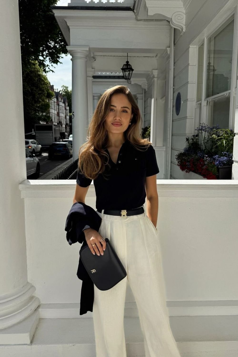 Femme portant le pantalon large Palazzo "Marbella" Riviera en lin écru, ajusté par une ceinture fine dorée.